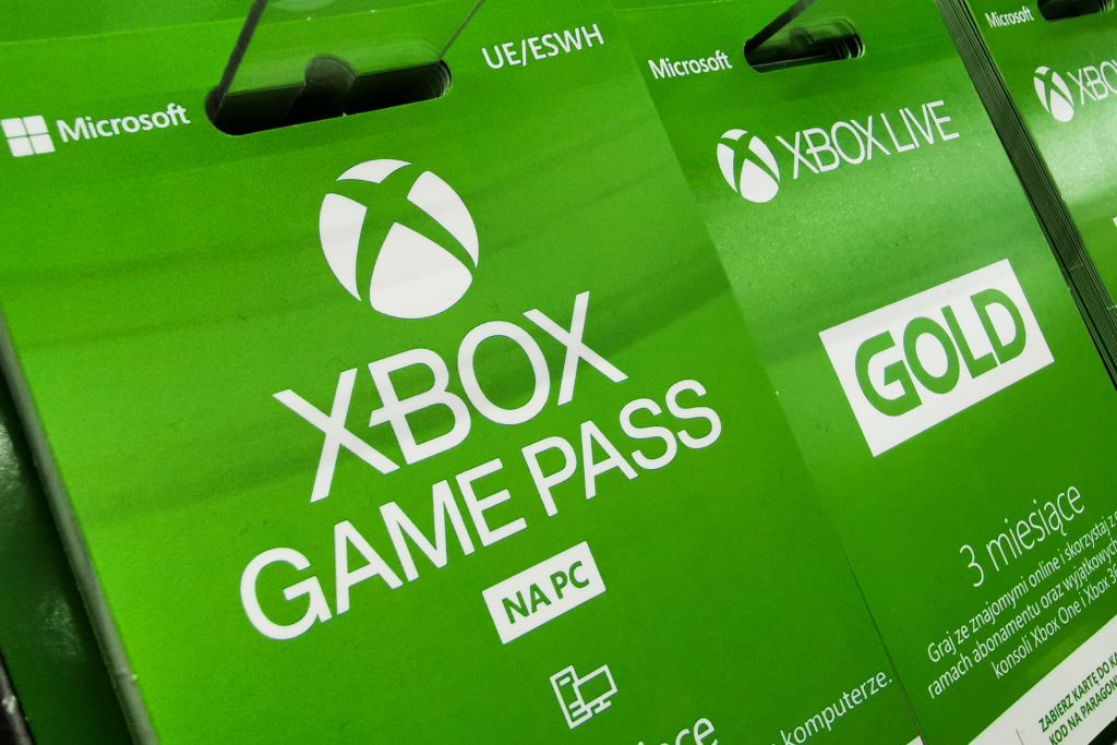 Controle de Xbox em frente a uma tela com o logotipo do Xbox Game Pass.