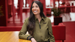 Asha Sharma, CEO do Xbox, sentada em uma mesa de madeira